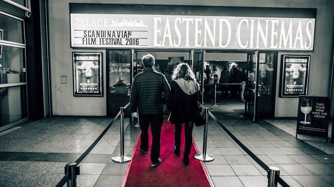 Two people walking on red carpet into the Palace Nova East End Cinemas, Adelaide
