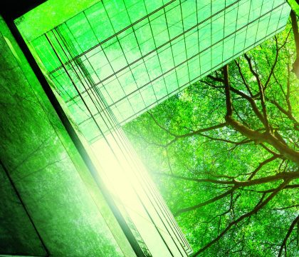 Sustainble green building. Eco-friendly building in modern city. Sustainable glass office building with tree for reducing carbon dioxide. Office with green environment. Corporate building reduce CO2.
